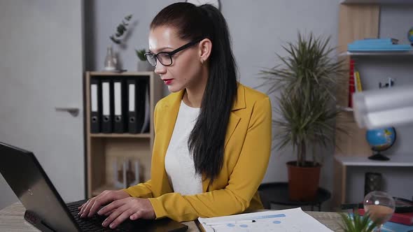 Brunette Business Lady in Trendy Jacket which Working in Home Office on Computer alt