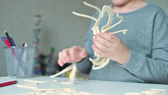 Close-up of a wooden toy in the hand of a child who assembles it with his own alt