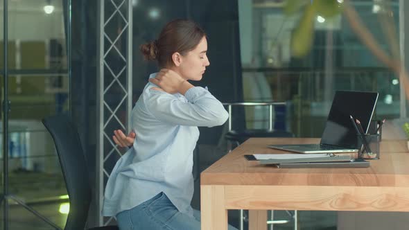 Woman Work at a Table With a Laptop Suddenly Feeling Pain in Neck and Back alt