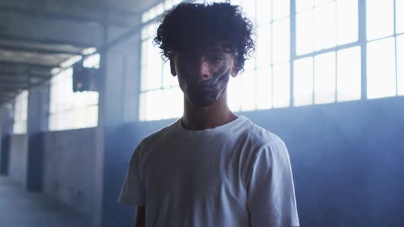 Portrait of african american man with hand mark on their mouth standing in empty parking garage alt
