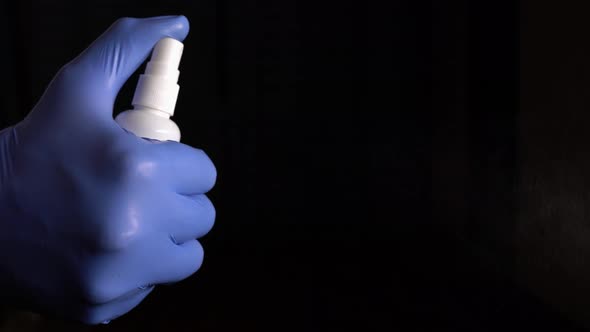 Medic In Blue Gloves Sprinkles With Antiseptic For Disinfection