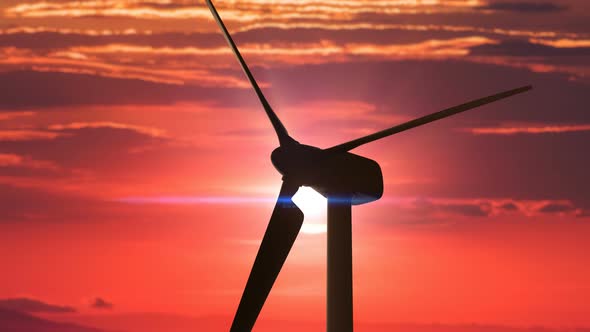 Silhouette of the Wind Turbine with Big Spinning Blades Against the Red Sunset 4k alt