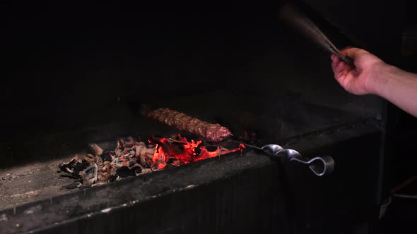 Lula kebab is fried on a skewer on a grill with hot coals. Concept street food