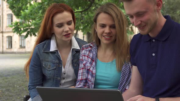 Young People Watch Something on Laptop on Campus
