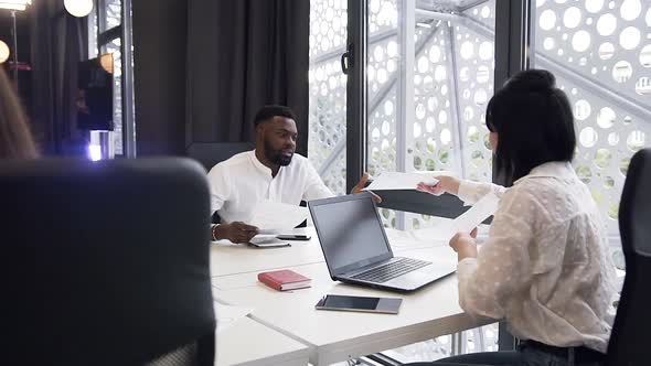 Attractive Mixed Races Female and Male Business People Working with Documents in the Office alt