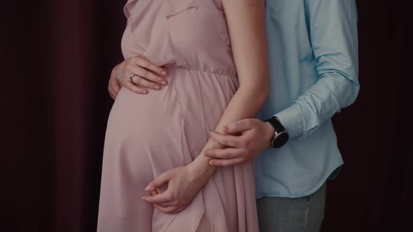 A Pregnant Woman and Her Husband are Holding Hands