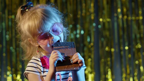 Stylish Trendy Young Child Girl at Disco Party Cyberpunk Club Eating Big Chocolate Bar Sweet Candy alt
