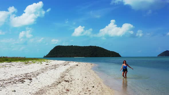 Sexy fun women on holiday spending quality time at the beach on paradise white sand and blue 4K back alt