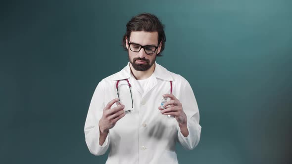 An Attractive Young Doctor Tries Comparing Two Ampules with Vaccine alt