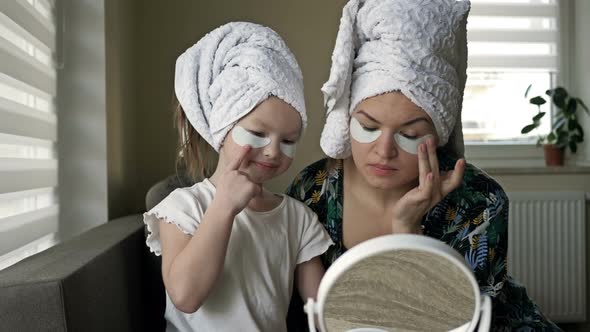 Young Woman and Her Little Daughter Are Doing Beauty Treatments After a Shower alt