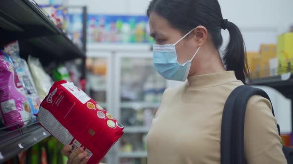 Asian woman wearing protective face mask shopping buying foods at supermarket.