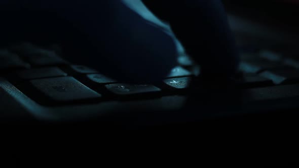 Silhouette of Male Fingers Typing in the Darkness