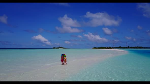 Man and woman posing on marine coast beach vacation by aqua blue sea with white sandy background of  alt