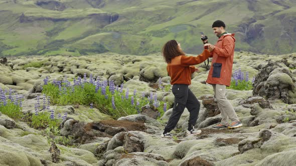 Man Photographing Hiking Partner In Mossy Landscape alt