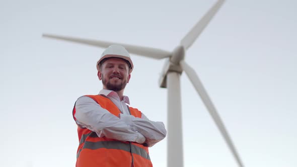 Confident Engineer with Folded Hands on His Chest, Against the Background of a Windmill, A Smiling alt