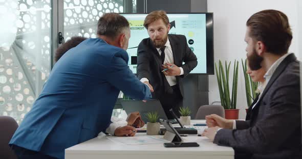 Bearded Boss Shaking Hand with Anothers Members of Joint Negotiations alt