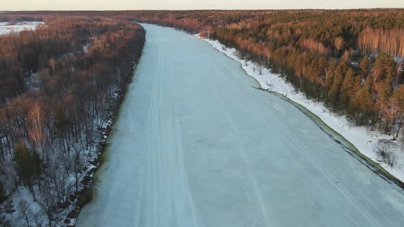 Unusual Winter Landscape with a Frozen River at Sunset Aerial View alt