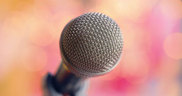 Microphone on Stage Against a Blurry Light ,Blurry Background. alt