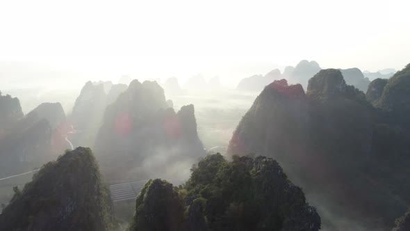 Aerial footage of beautiful sunrise over karst mountain peak landscape alt