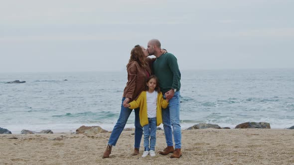 Young Happy Family Standing On Ocean Beach