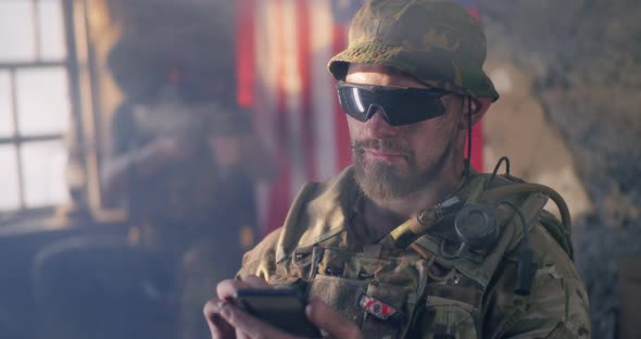 American Soldier Browsing Smartphone During War alt