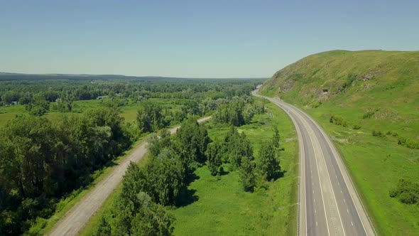 Aerial: Flying Vertically Upward, Above the Highway, in Mountainous Area alt
