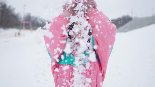 Cheerful Slim Young Woman in New Year Hat Tossing White Snow in Slow Motion Outdoors Smiling alt