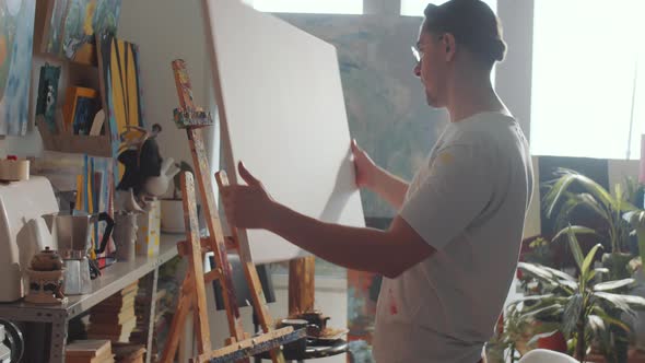 Artist Setting Canvas in Easel alt