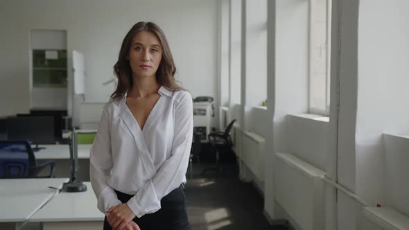 Serious Woman Stands in Office Room alt