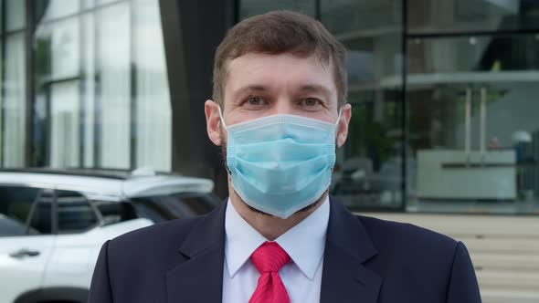 Portrait Handsome Bearded Senior Business Man Wearing a Medical Mask to Protect Against Coronavirus alt