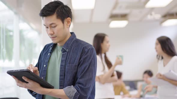 Asian man using tablet in office alt