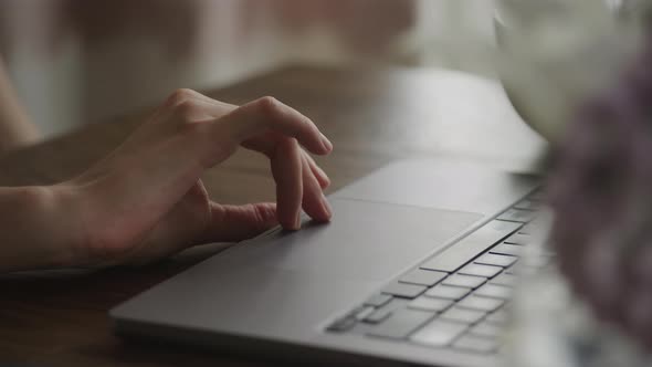 Camera Pivoting Around a Close Up of a Woman Hand Swipe on a Laptop Computer Touchpad alt
