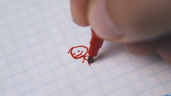 Young Man Draws Funny Human Using Red Marker on Paper alt