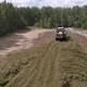 Drone view of tractor tamp the silage in the Silo Trench next to the forest 06 - VideoHive Item for Sale