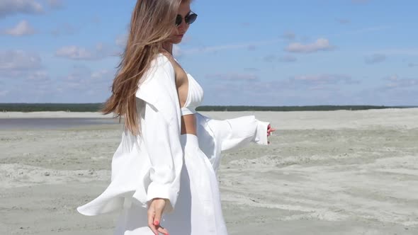 Charming Woman Standing on Beach on Windy Day