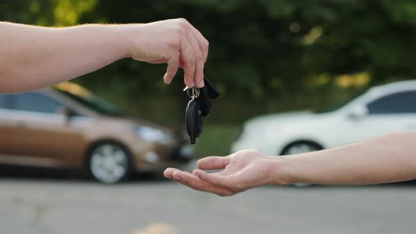 Man Gives a Car Key To the Other Man alt