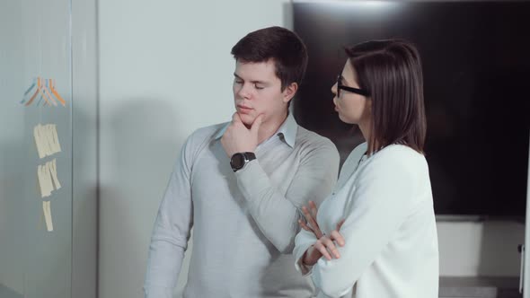 Project Management Team Monitoring Tasks on Agile Board in Office alt