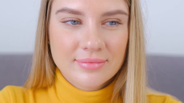 Video portrait of attractive white female with blue eyes working on computer at home in 4k footage alt