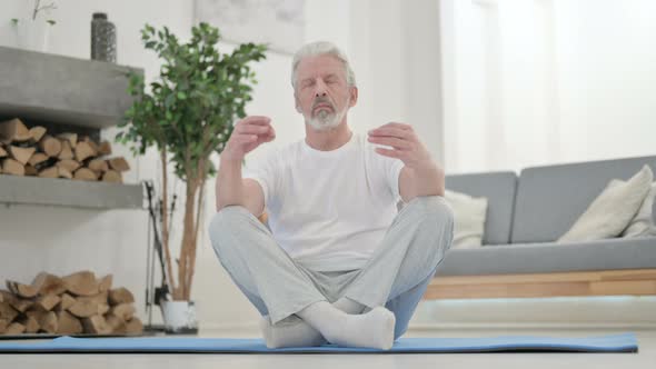 Peaceful Old Man Meditating on Yoga Mat at Home alt