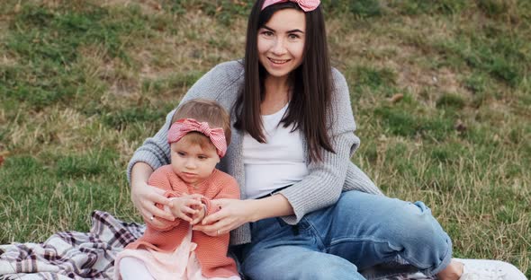 Mother and a Small Daughter, Spends Time Together in a City Park on a Picnic, Young Woman and Little