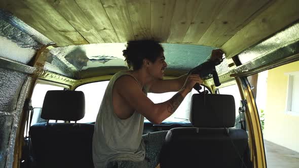 Man creating lumber ceiling in van alt