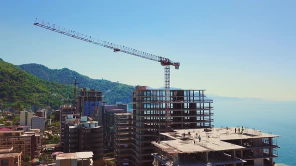 Drone view of construction site multi-storey buildings against background of sea alt