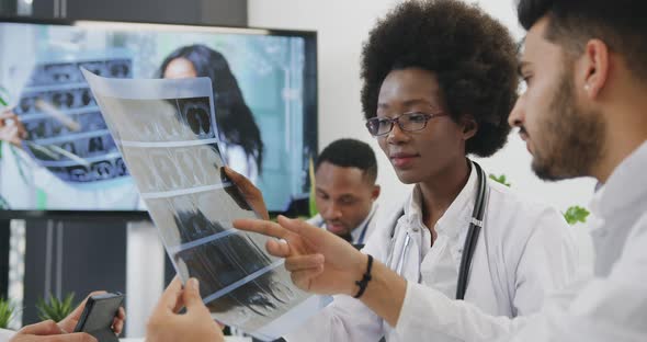 Doctors Discussing Patient's X-ray and Deciding the Method of Treatment During Joint Conference alt