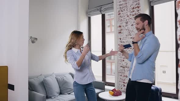Modern Guy and Girl which Funny Dancing with their Passports in Hotel Room alt