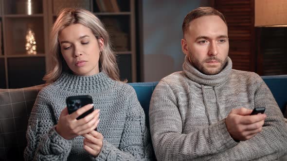 Winter Man and Woman Suffering Internet Television Addiction Spending Time at Evening Home on Couch