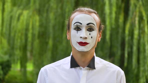 Fun Mime Looking at the Camera on Green Background in a Park alt