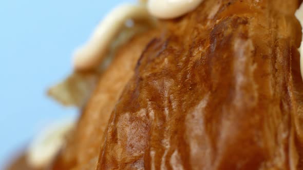 Macro shot of a croissant dessert on a blue background. Baking, dessert with coffee. alt