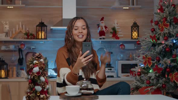 Cheerful Woman on Christmas Video Call with Friends at Home alt