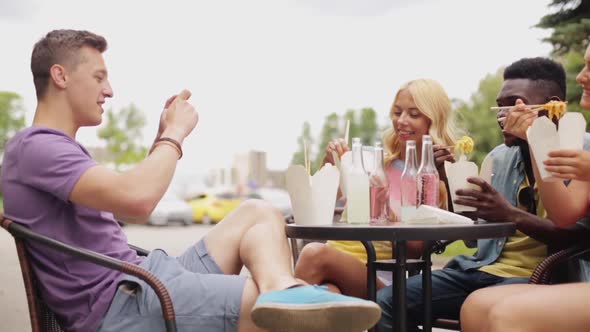 Man Taking Video of Friends Eating at Food Truck alt