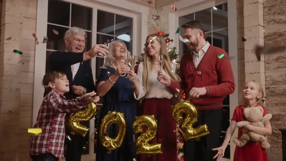 Happy Family Celebrate New Year 2022 Laugh and Hug Clanging Glasses